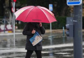 Un hombre se protege de la lluvia bajo su paraguas .